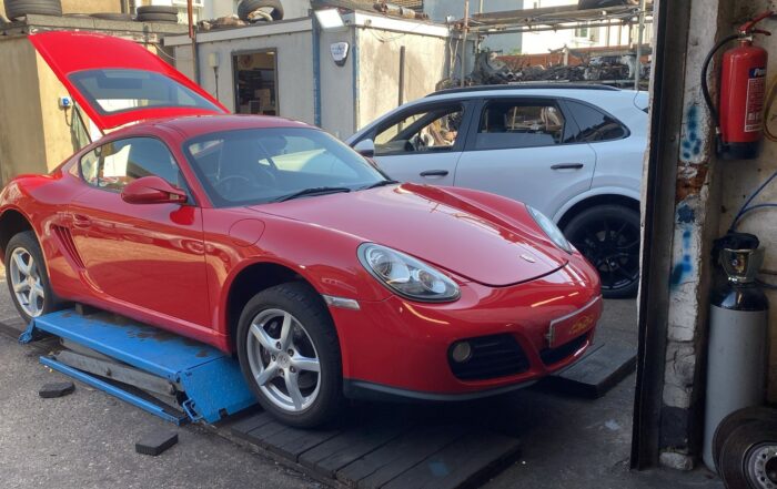 Red Porsche Cayman one-owner car in for service and air conditioning regas
