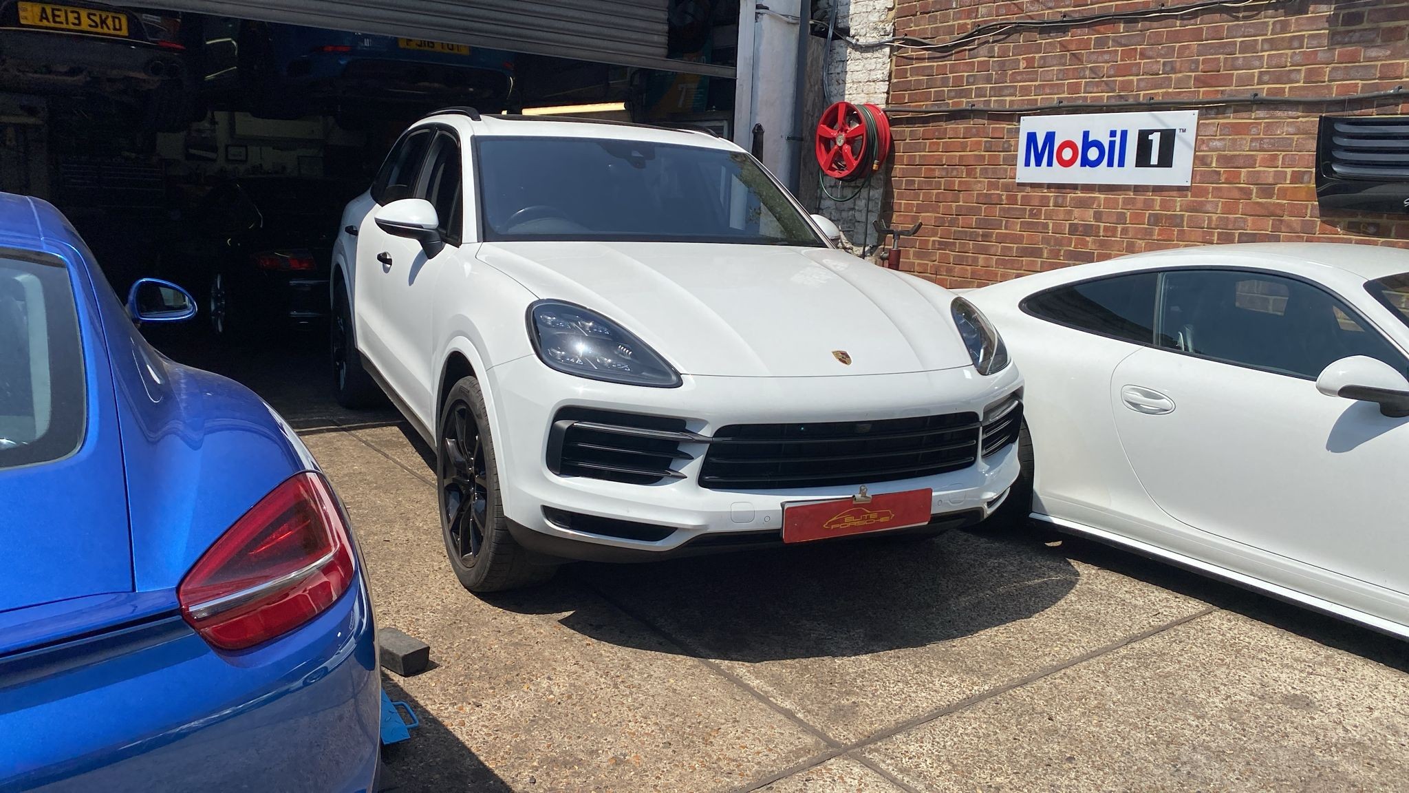 White Porsche Cayenne outside the workshop for full service and transfer box oil change